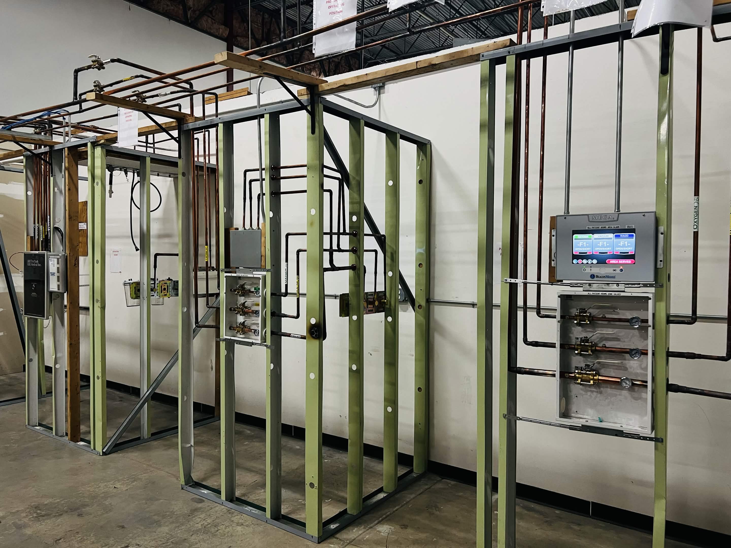 Medical gas training lab with piping routed across wall panels